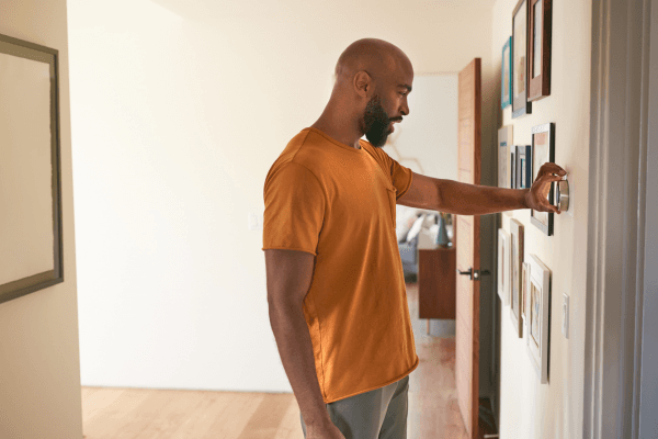 Display ad for MGE; image of person adjusting thermostat